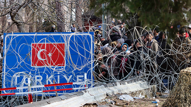 Geflüchtete vor Stacheldraht an der türkisch-griechischen Grenze